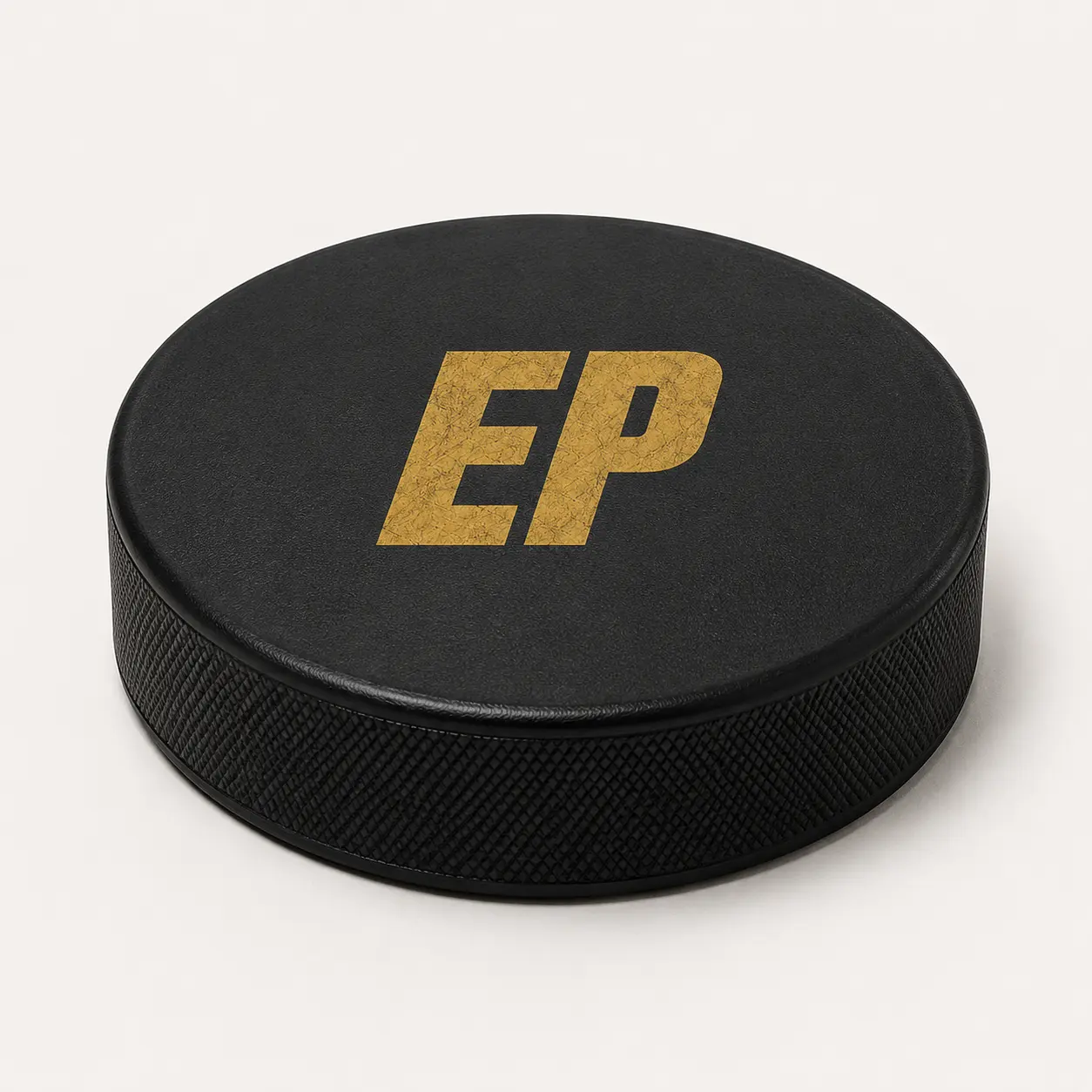 Black hockey puck with gold EP monogram