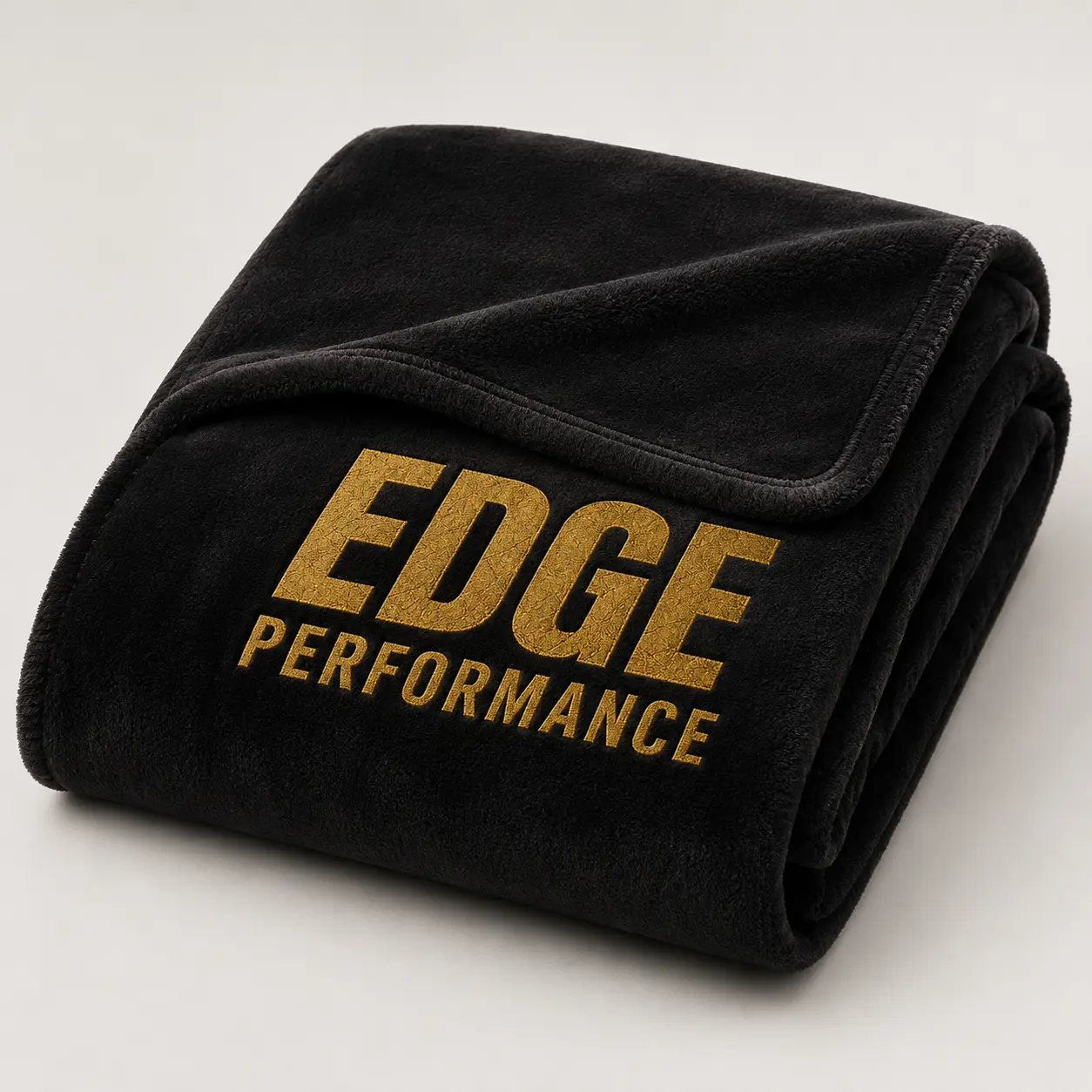 Folded black EDGE rink blanket with gold wordmark