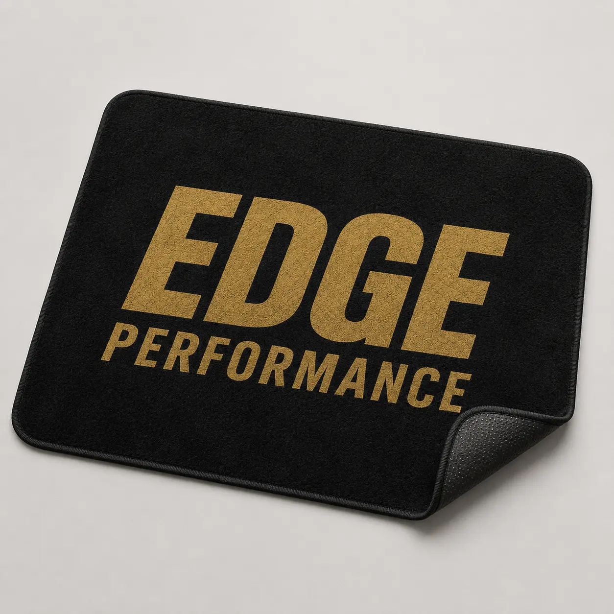 Black EDGE skate mat with large gold wordmark and rubber backing