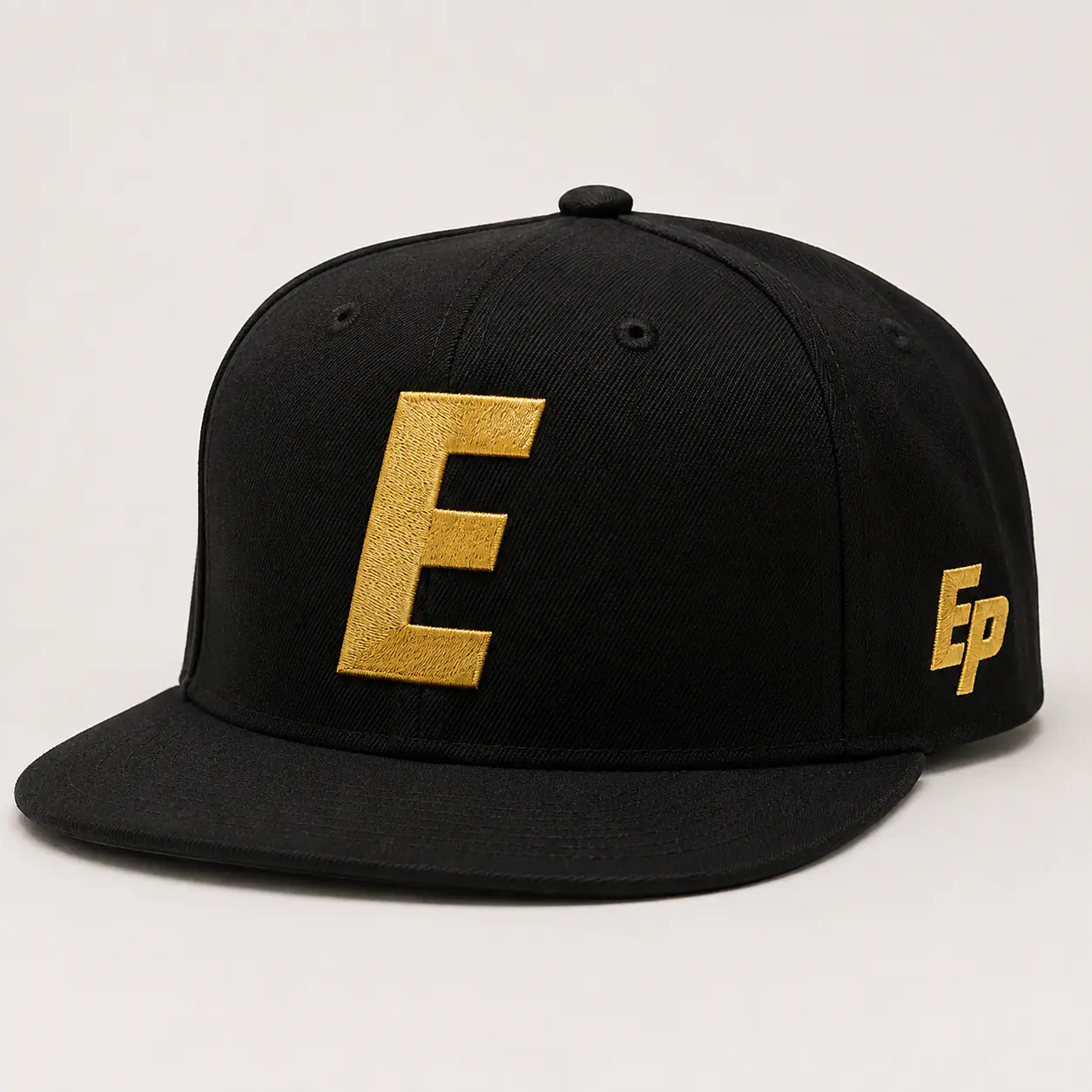 Black snapback with oversized gold EDGE E monogram