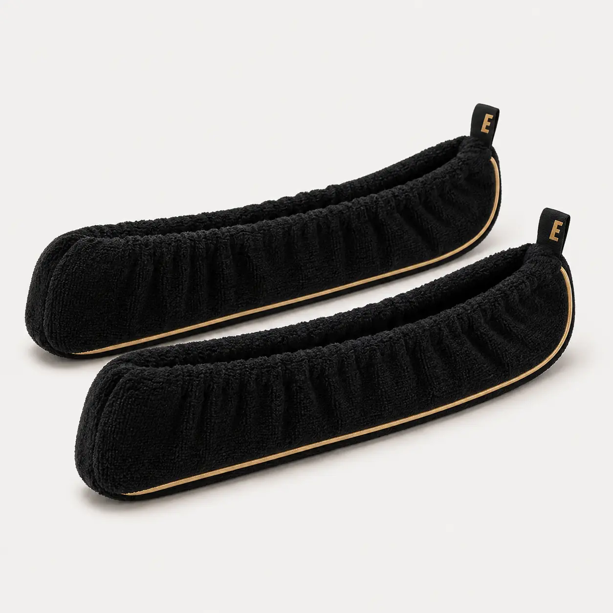 Pair of black EDGE skate soakers with gold piping